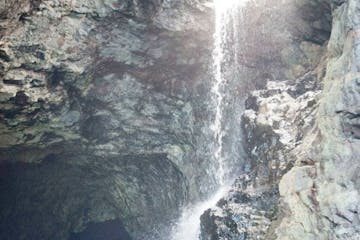a large waterfall next to a rock