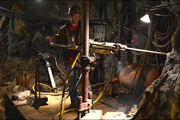 Man operating old mining equipment.