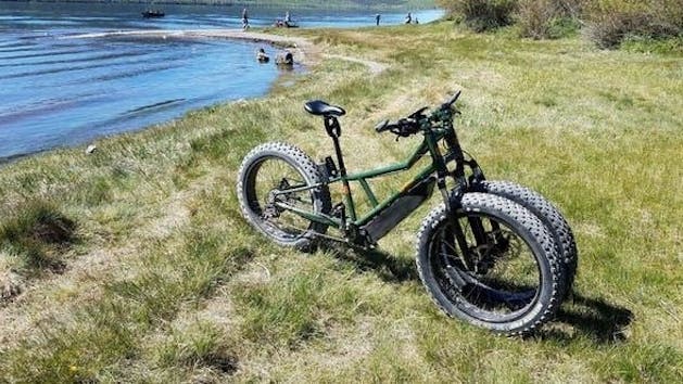 Rungu Electric Bike parked on the side of a dirt field