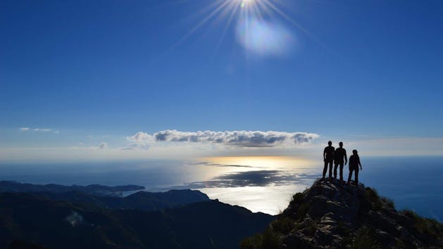 People on top of mountain with sun