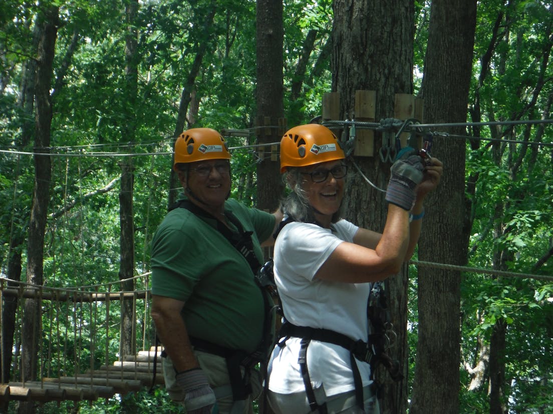 Man and woman on ziplining obstacle course