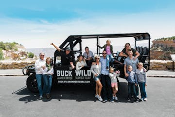 A tour group posing with one of the custom hummers