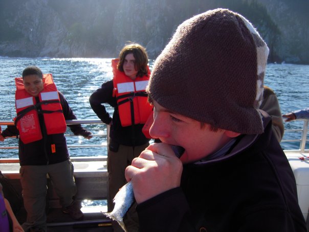 Child eats herring on boat