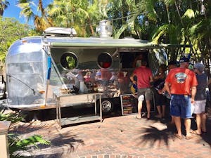 Silver airstream trailer where Garbo's Grill serves food in Key West beside Grunt's bar