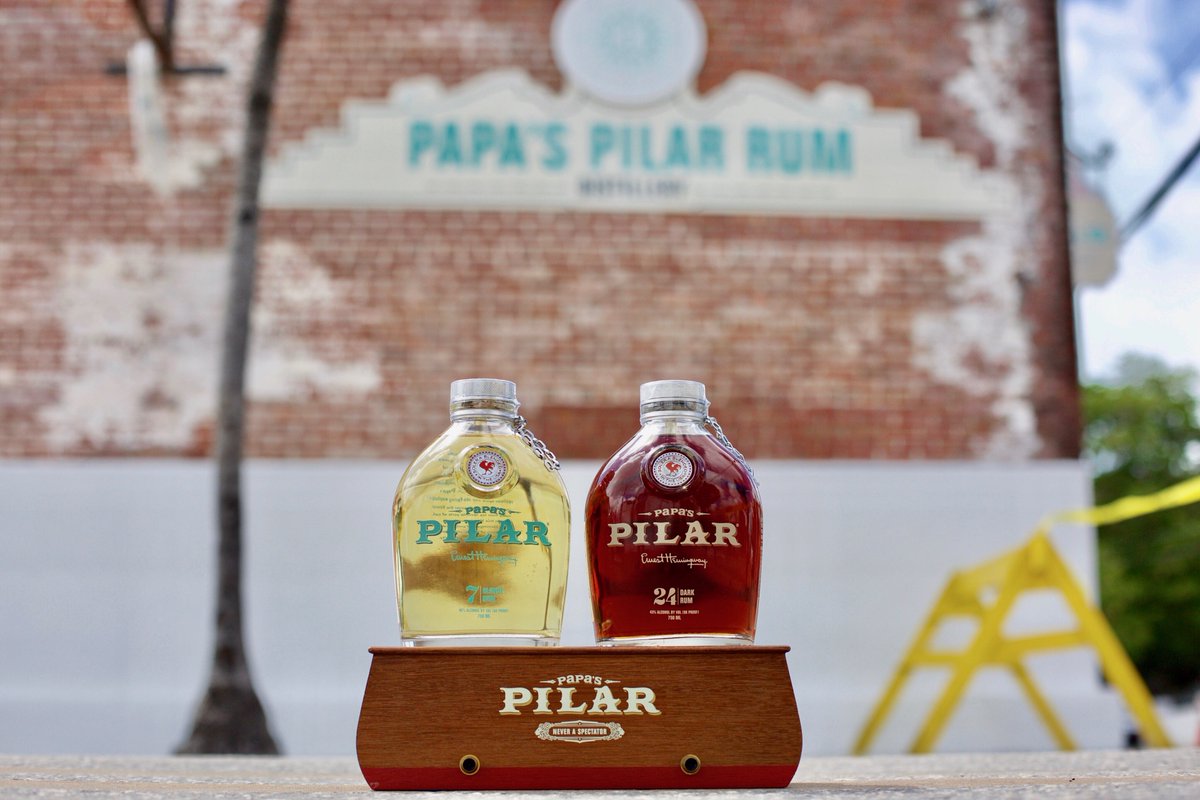 Hemingway Rum Company's Papa's Pilar Blonde and Dark Solera aged rum blends atop a wooden pedastal in front of distillery. 