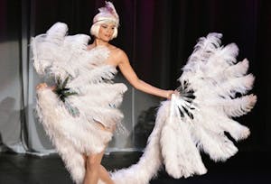 a flapper style vegas show girl with large white feather fan