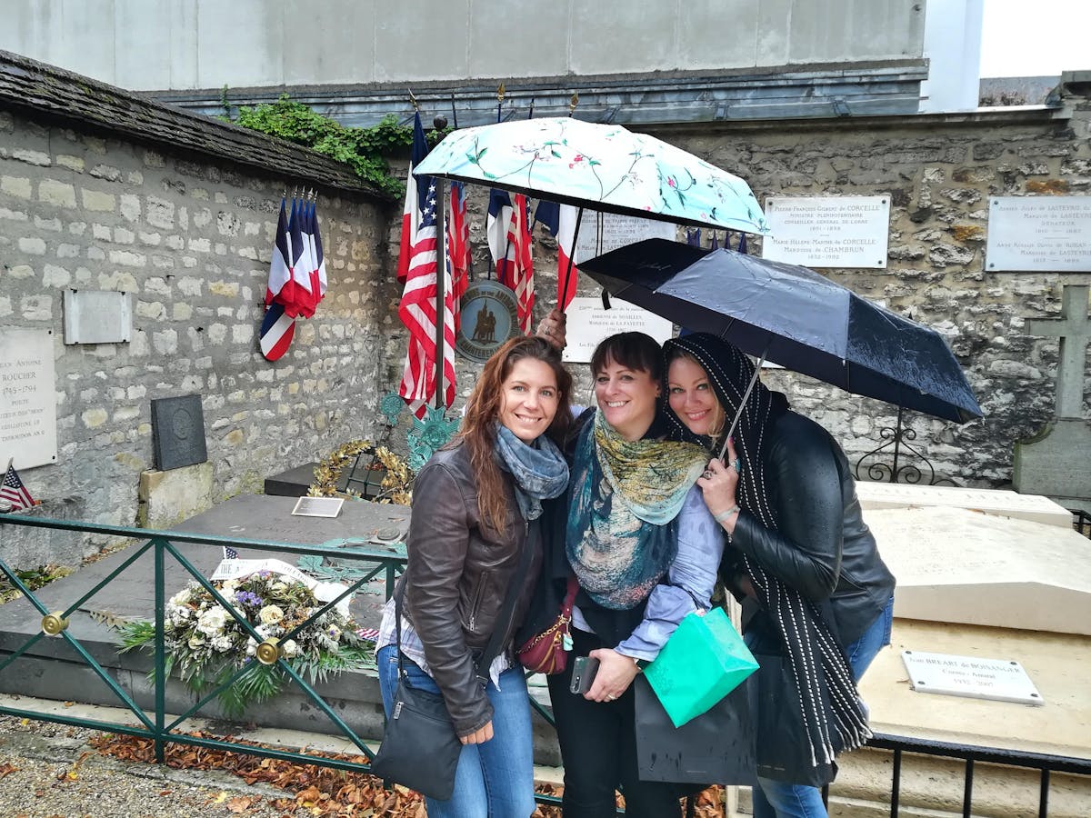 Three women posing in front of a memorial