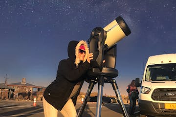 Woman looking through a telescope