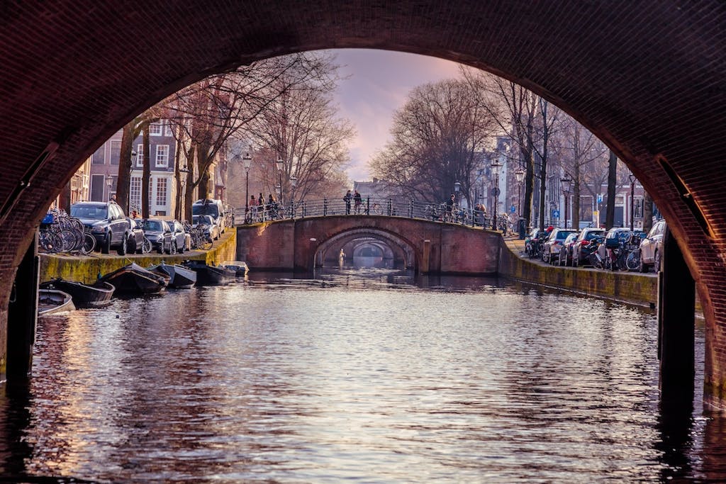 people walking on a bridge above the canals of Amsterdam