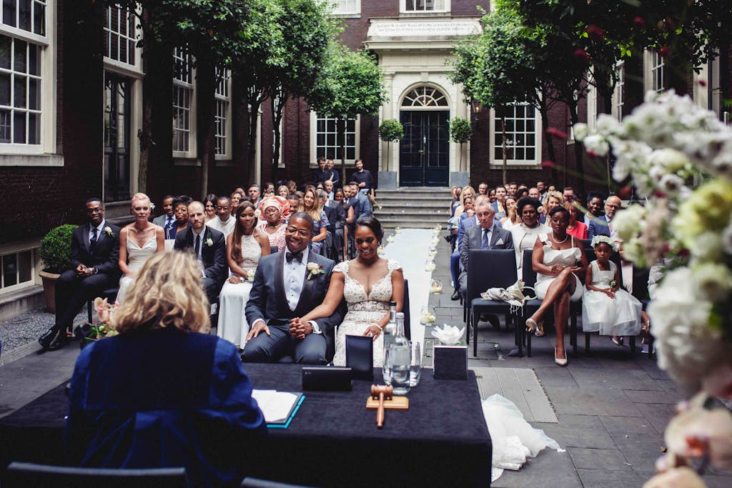a group of people sitting in front of a building one of the romantic hotels in Amsterdam for your proposal 