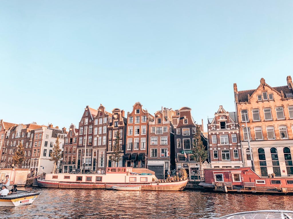 boats on the canals of Amsterdam and Dutch Houses on a sunrise 