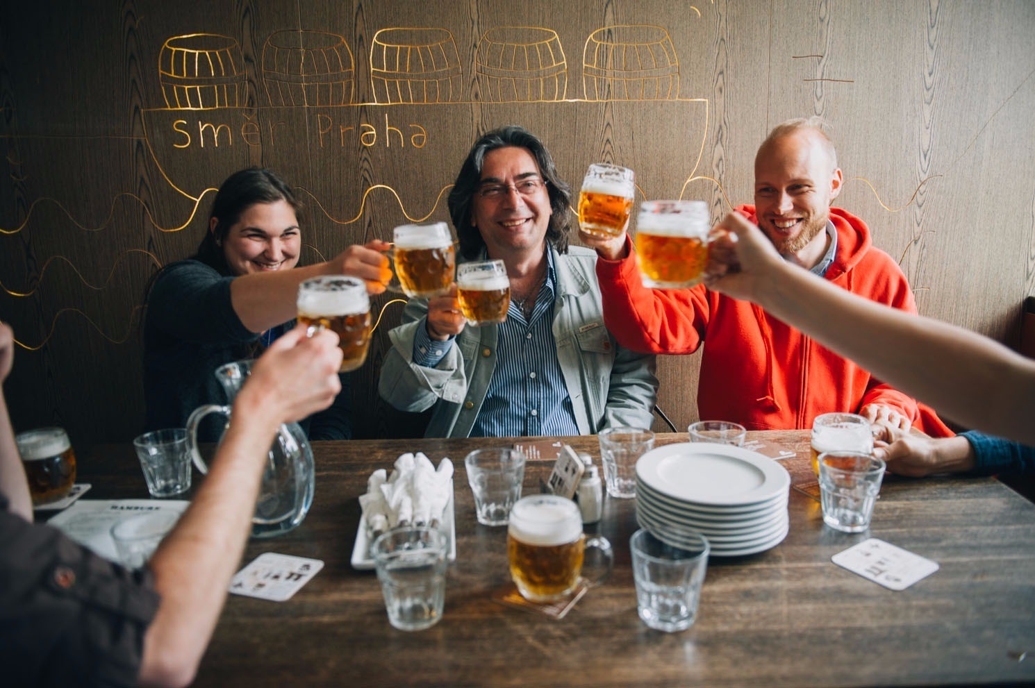 a group of tourists enjoying a glass of beer during a beer tour in Prague
