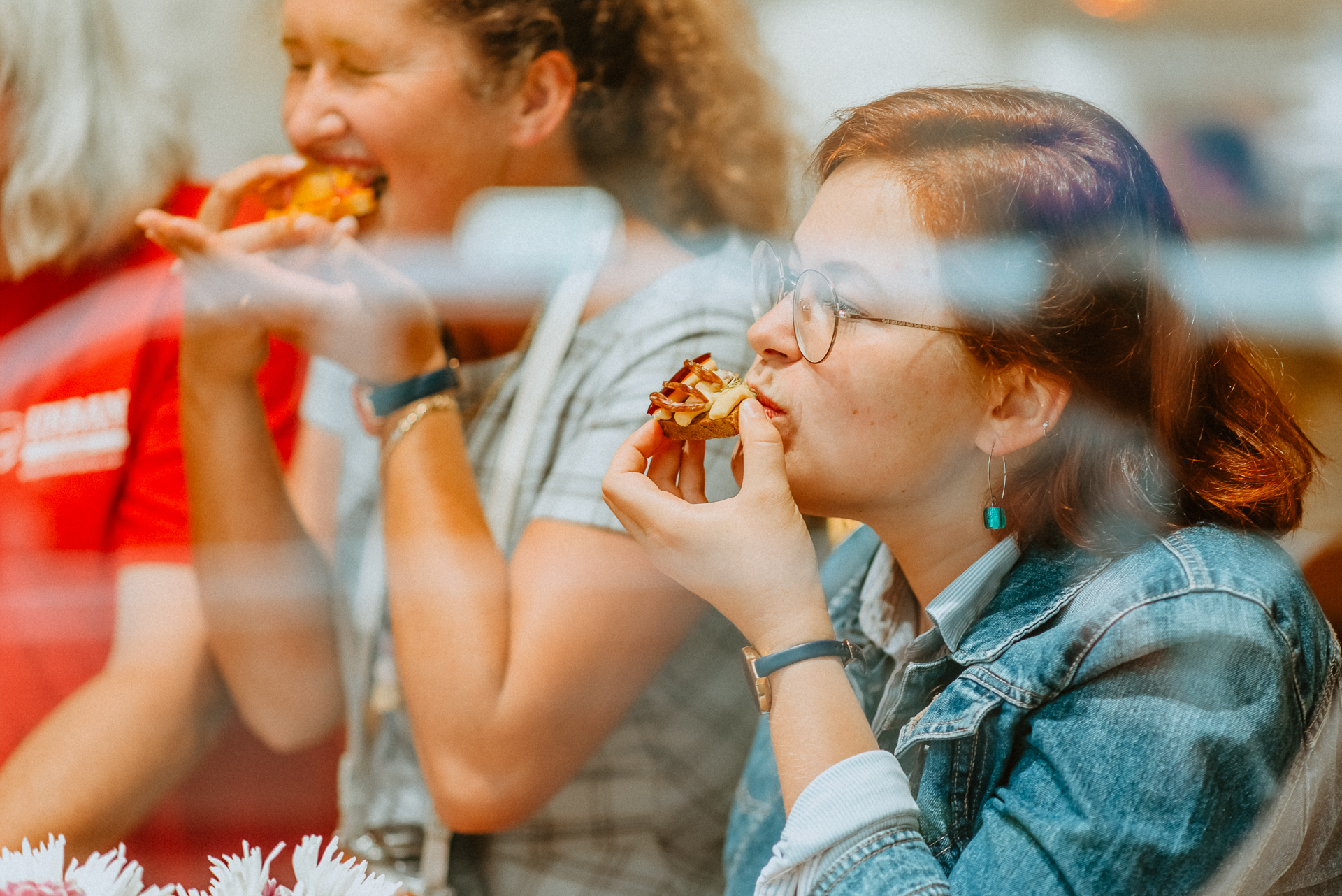 a young girl eating a hot dog