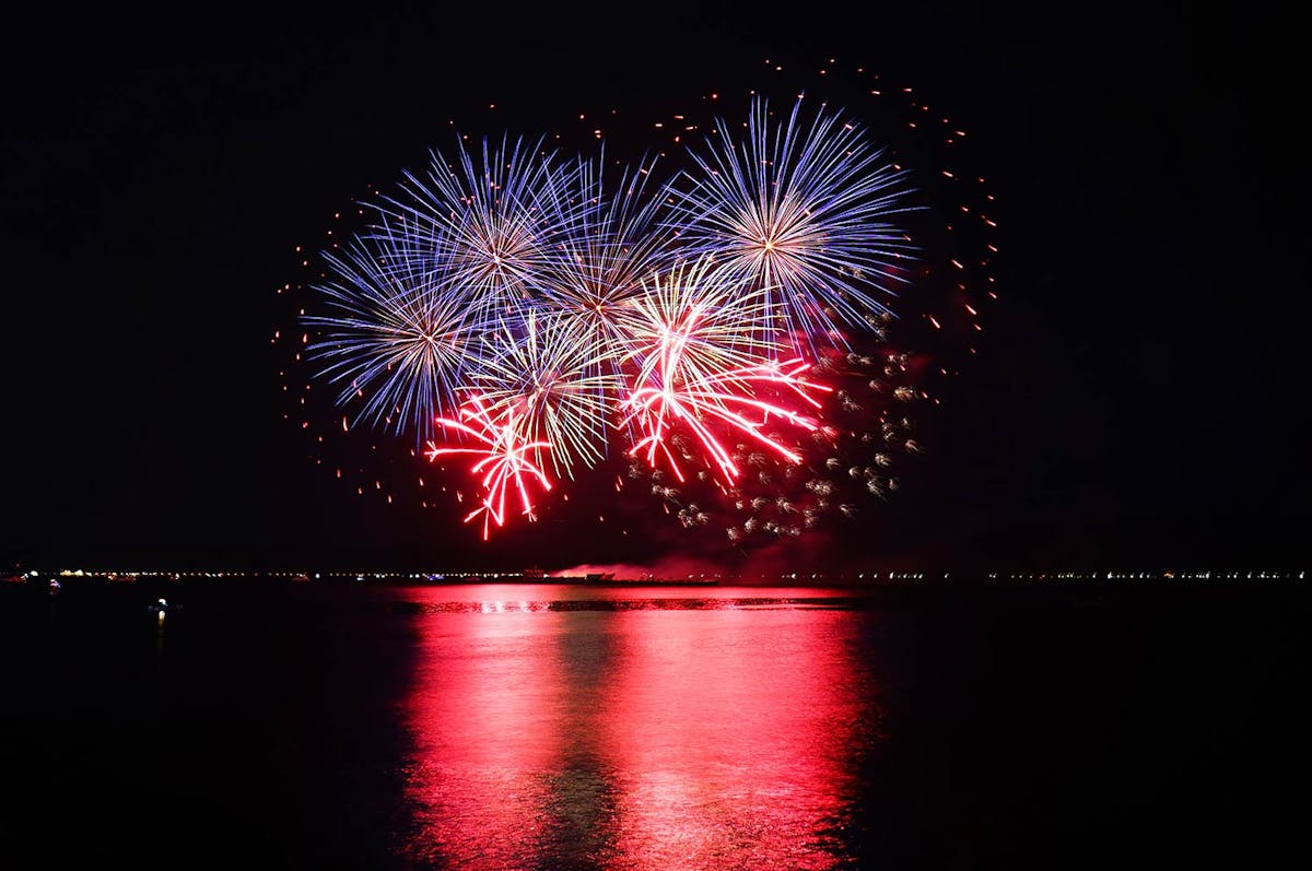Red and blue fireworks over water