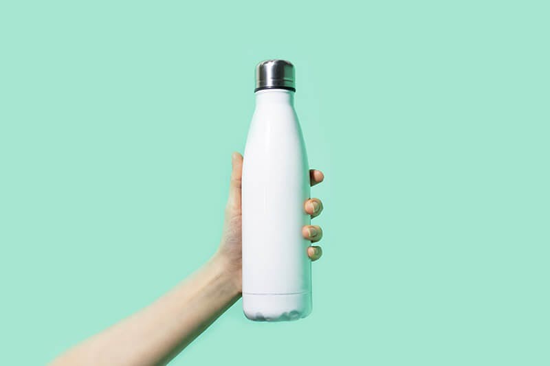 Hand holding white reusable bottle