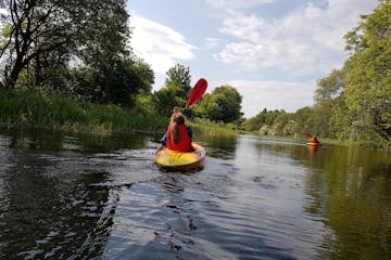 A girl kayaking down a river in Glasgow