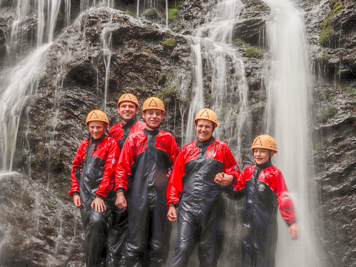 a group of people standing around a fire hydrant next to a waterfall