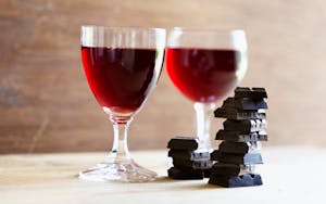 a glass of wine sitting on top of a wooden table