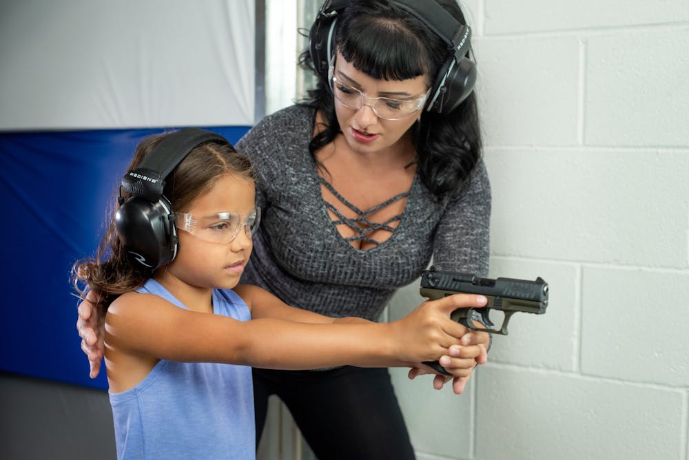 Kris Chanksi teaching little girl how to shoot a gun