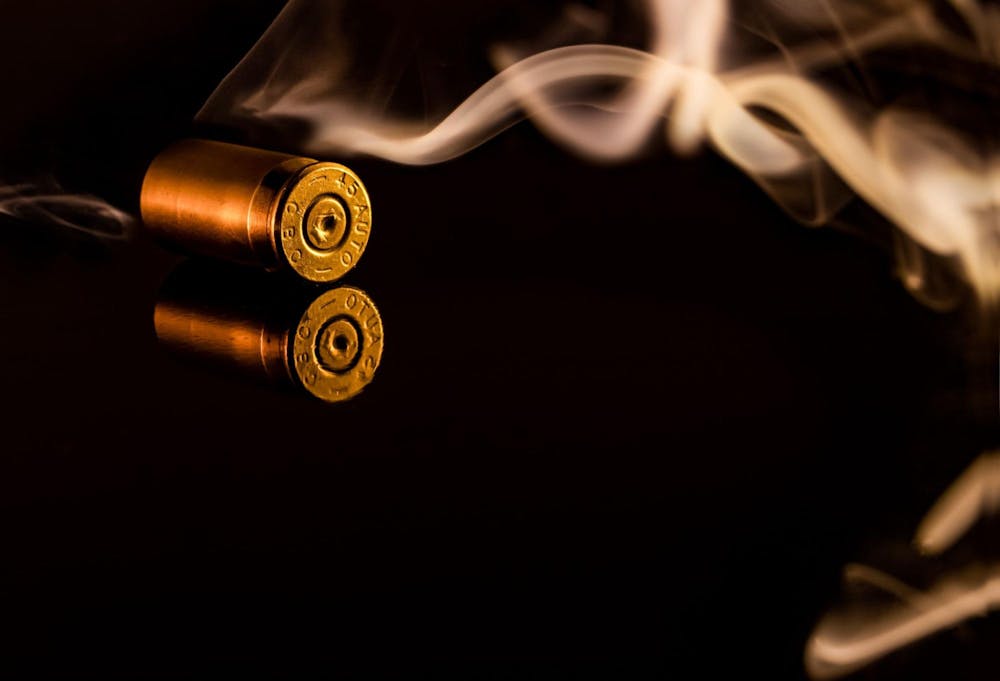 smoking gun with bullet on table