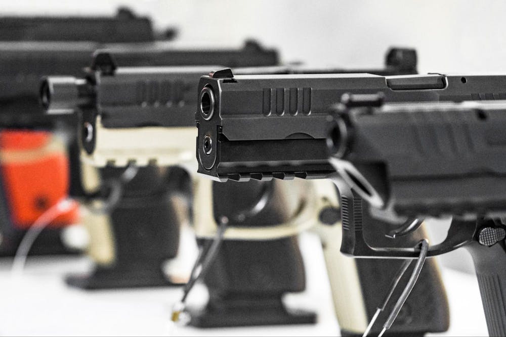 black pistols lined up standing upward on table
