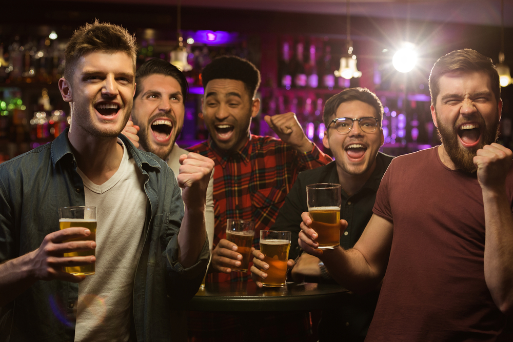 Group of young men drinking beer and celebrating
