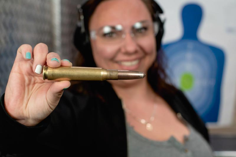 woman holding the 50 cal ammo