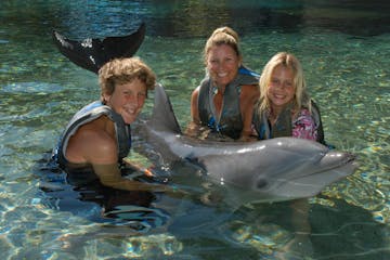 A family wearing wetsuit having a dolphin tour experience.