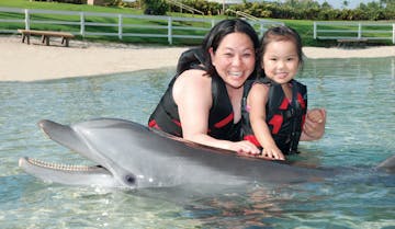 Mother and daughter wearing wetsuits on a dolphin tour experience.