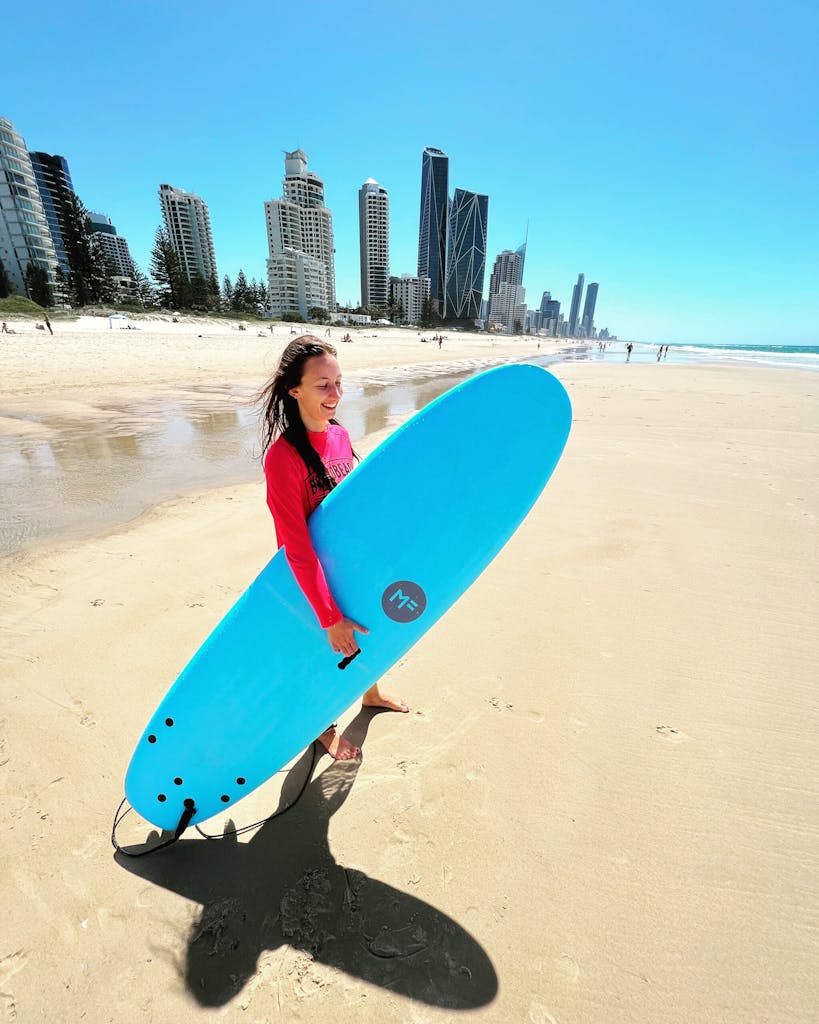 a person standing on a beach holding a surf board