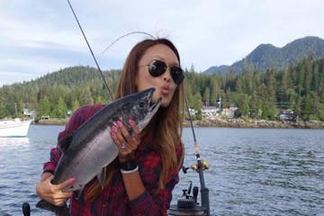 Girl taking a selfie with a salmon on a Ketchikan Charter Boat