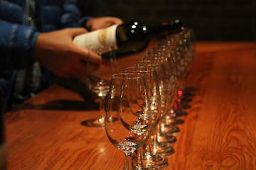 row of wine glasses being filled