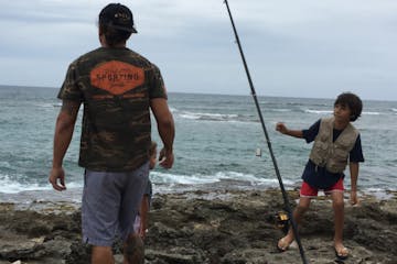 man and kid shoreline fishing oahu