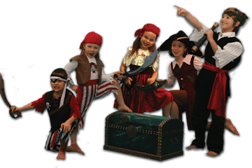 Children dressed as pirates smiling around a treasure chest