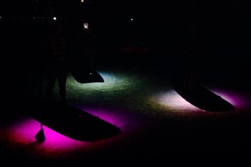 Glow paddle boards on lake