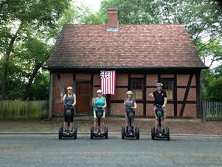 People on Segway PTs in front of house