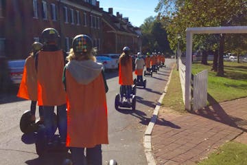 People on Segway PTs with orange capes