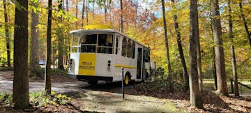 a bus drives through a wooded area