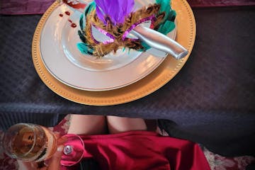 a person sitting at a table with a cake on a plate