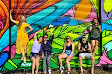 A group of people hanging out by graffiti in Hawaii