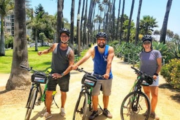 Three people standing next to bikes in los angeles
