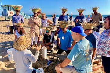 a group of people building sand castles for an la team building activity