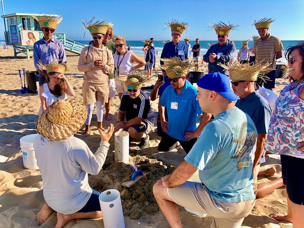 a group of people building sand castles for an la team building activity