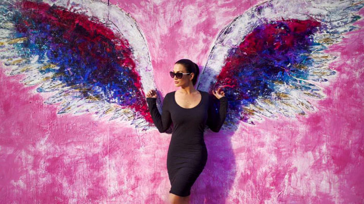 Christina Cindrich in front of angel wing mural
