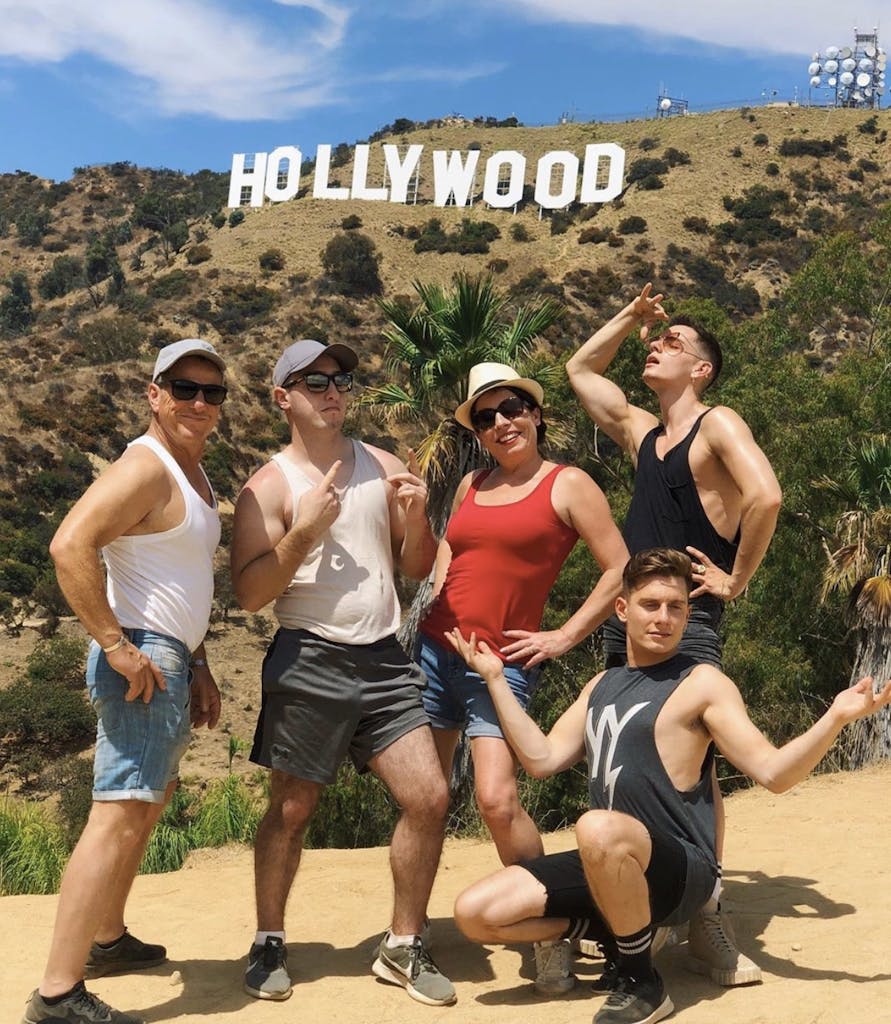 five people in front of hollywood sign