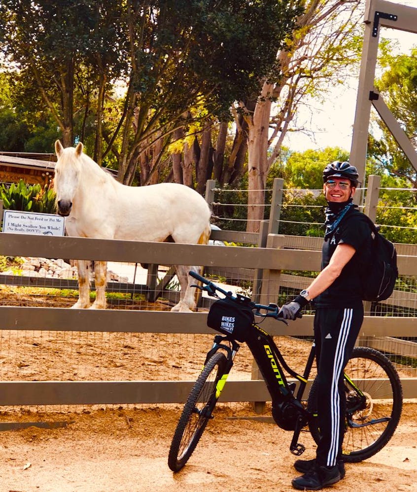 a person riding a horse next to a bicycle