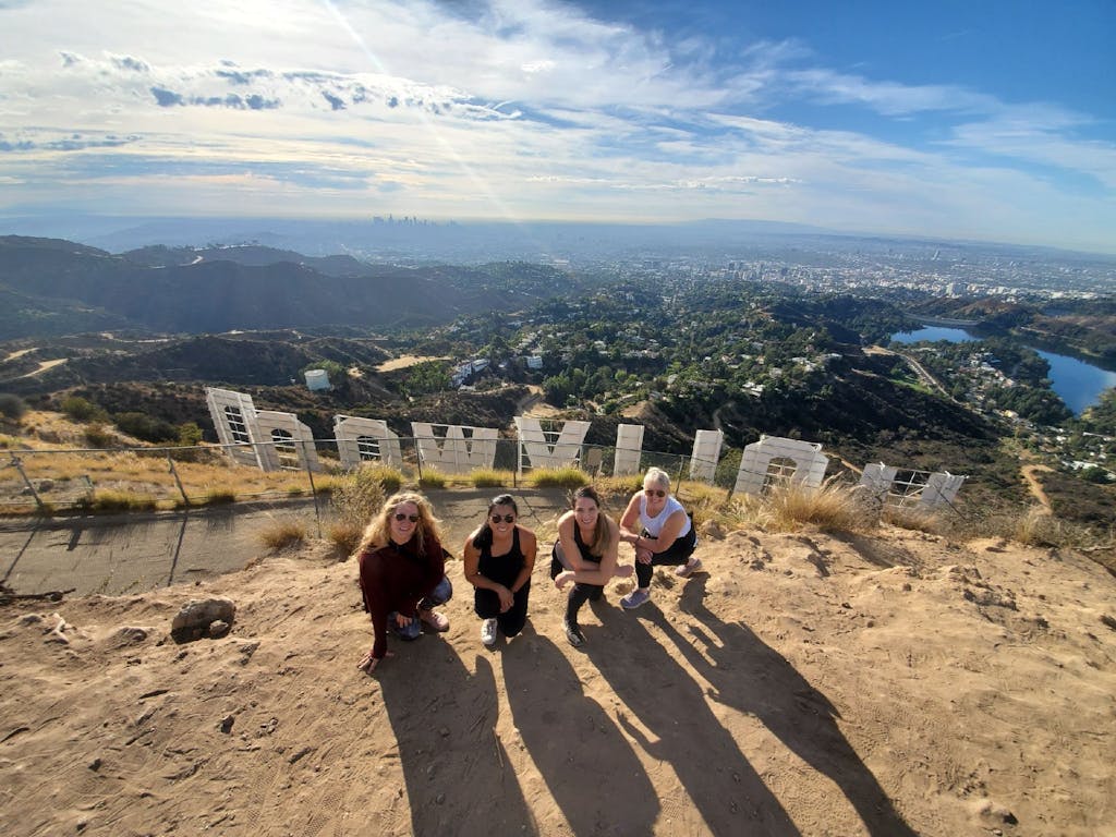 four girls hike behind the hollywood sign