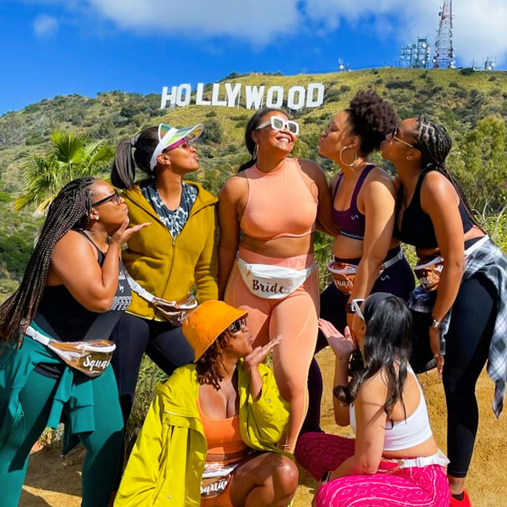 a group of people posing for the camera in front of the hollywood sign on a los angeles tour