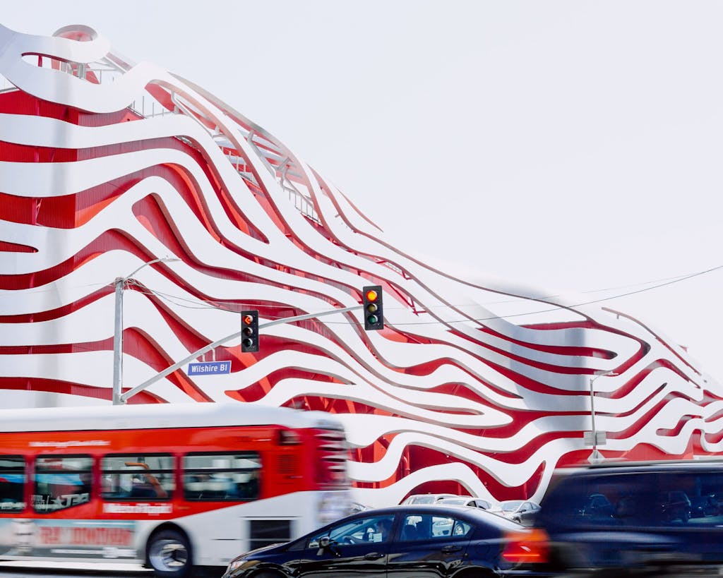 a close up of a bus with Petersen Automotive Museum in the background