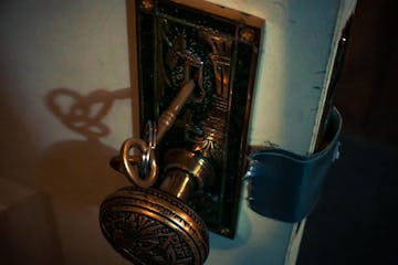 Door Knob with Key on White Wooden Door